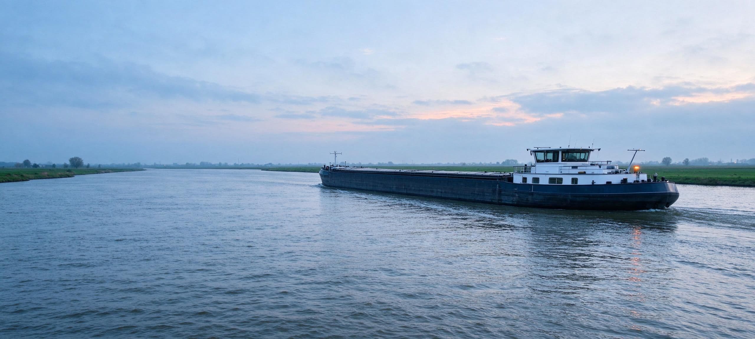 Tankschip op een brede rivier in de ochtend